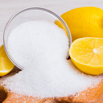 A bowl of citric acid granules with lemons showing its natural